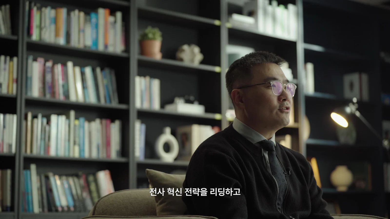 책장을 배경으로 촬영한 인터뷰 장면
